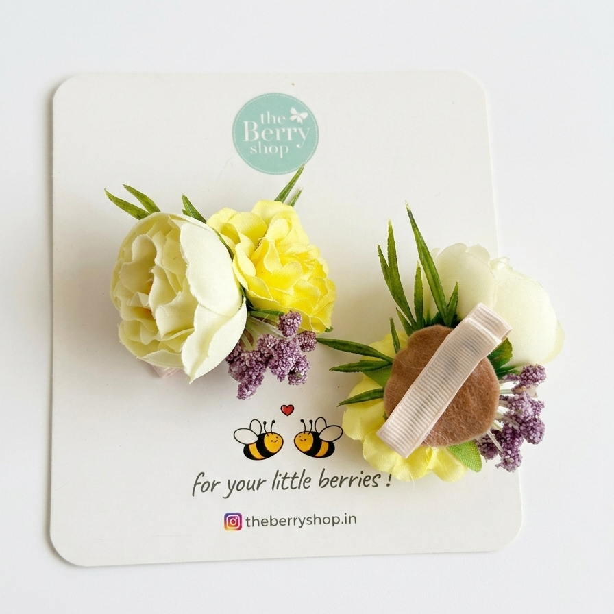 Cream and pastel yellow floral hair clip with green leaves and lilac accents for baby girls on Berry Shop display card.
