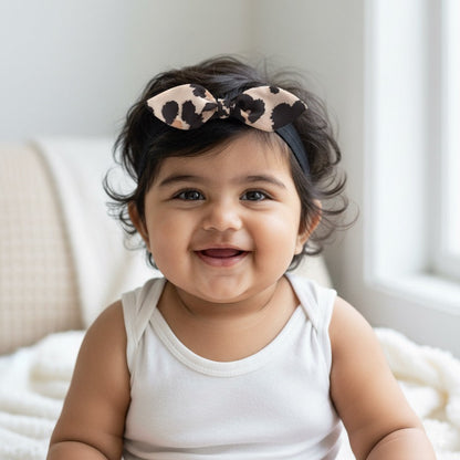 Black baby headband with beige and black leopard print knot bow for toddler girls.
